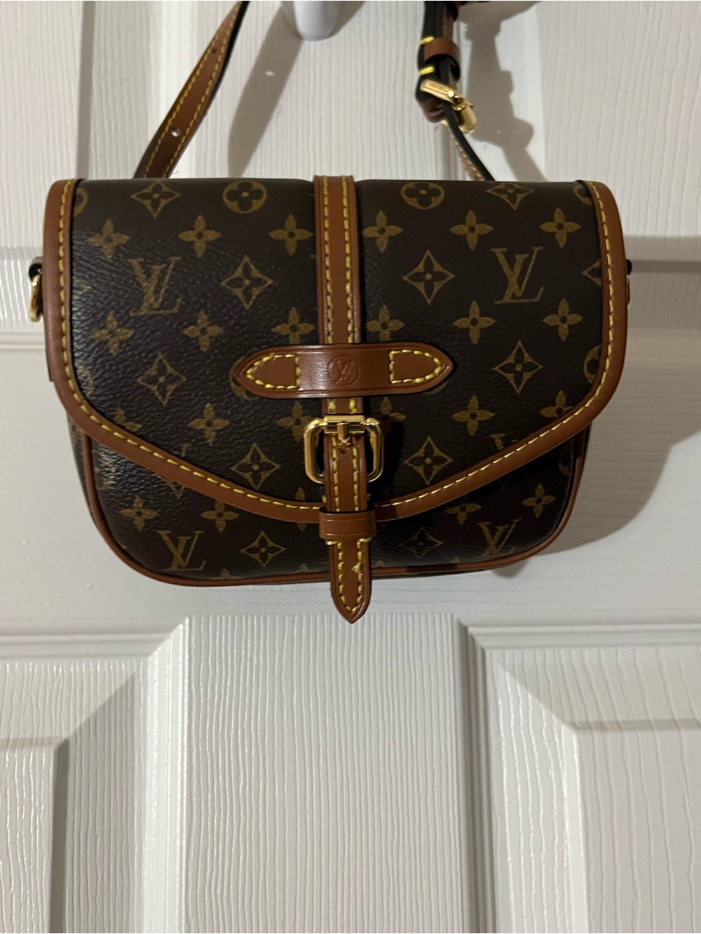 This is an imitation LV Louis Vuitton Brown Monogram Saddle Crossbody tan tote.